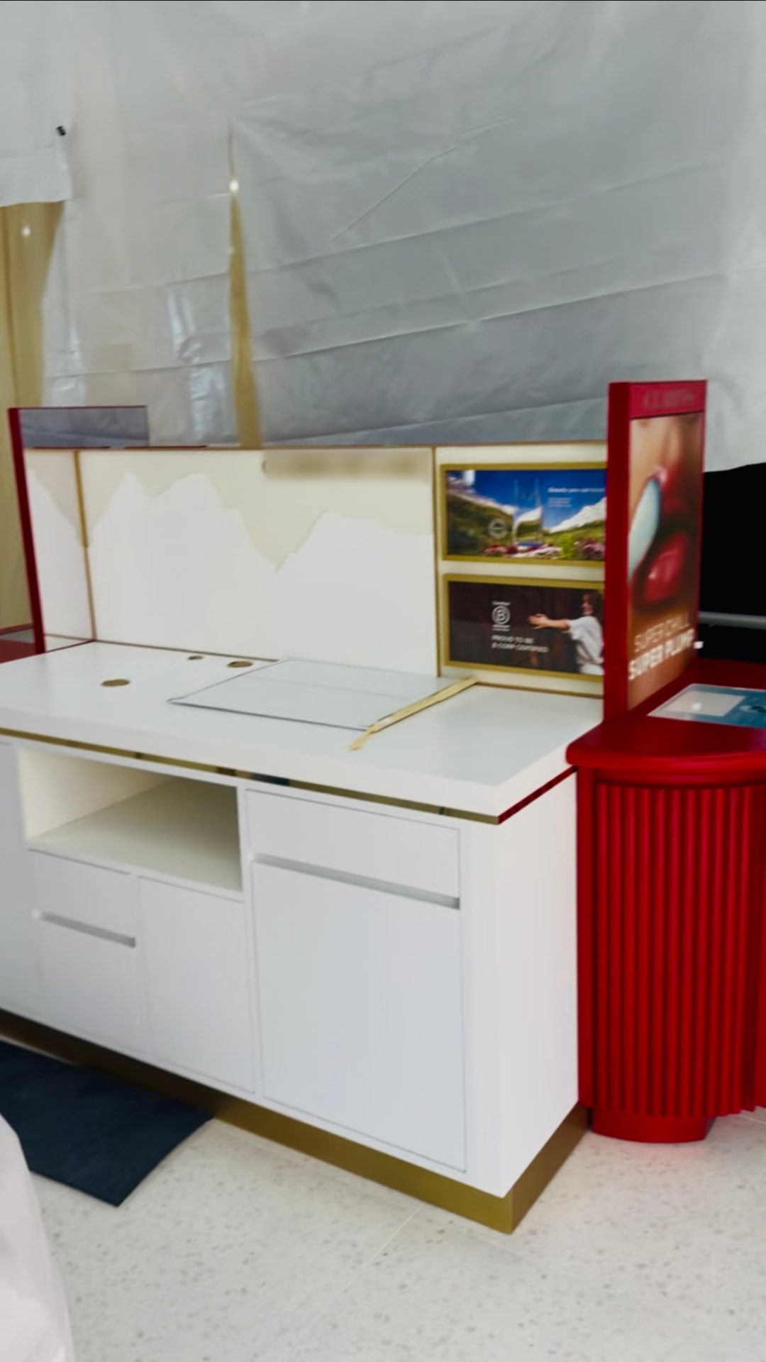 White counter with mountain panel backdrop and red ribbed column