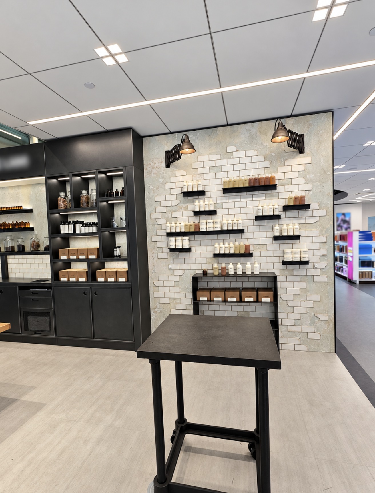 Front view of white brick-style tiled wall with black shelves and dark display unit