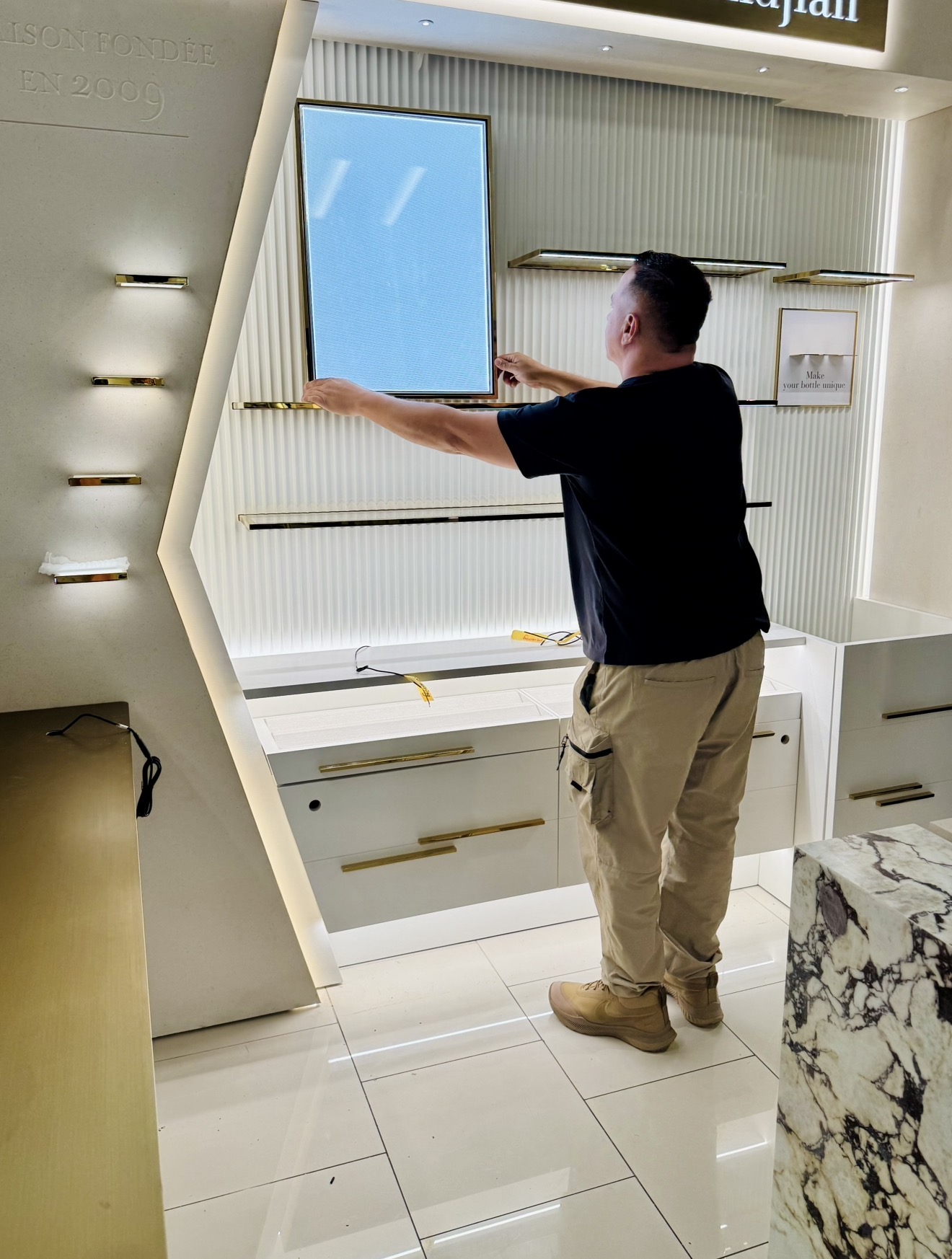 Installer mounting a large framed panel on a feature wall