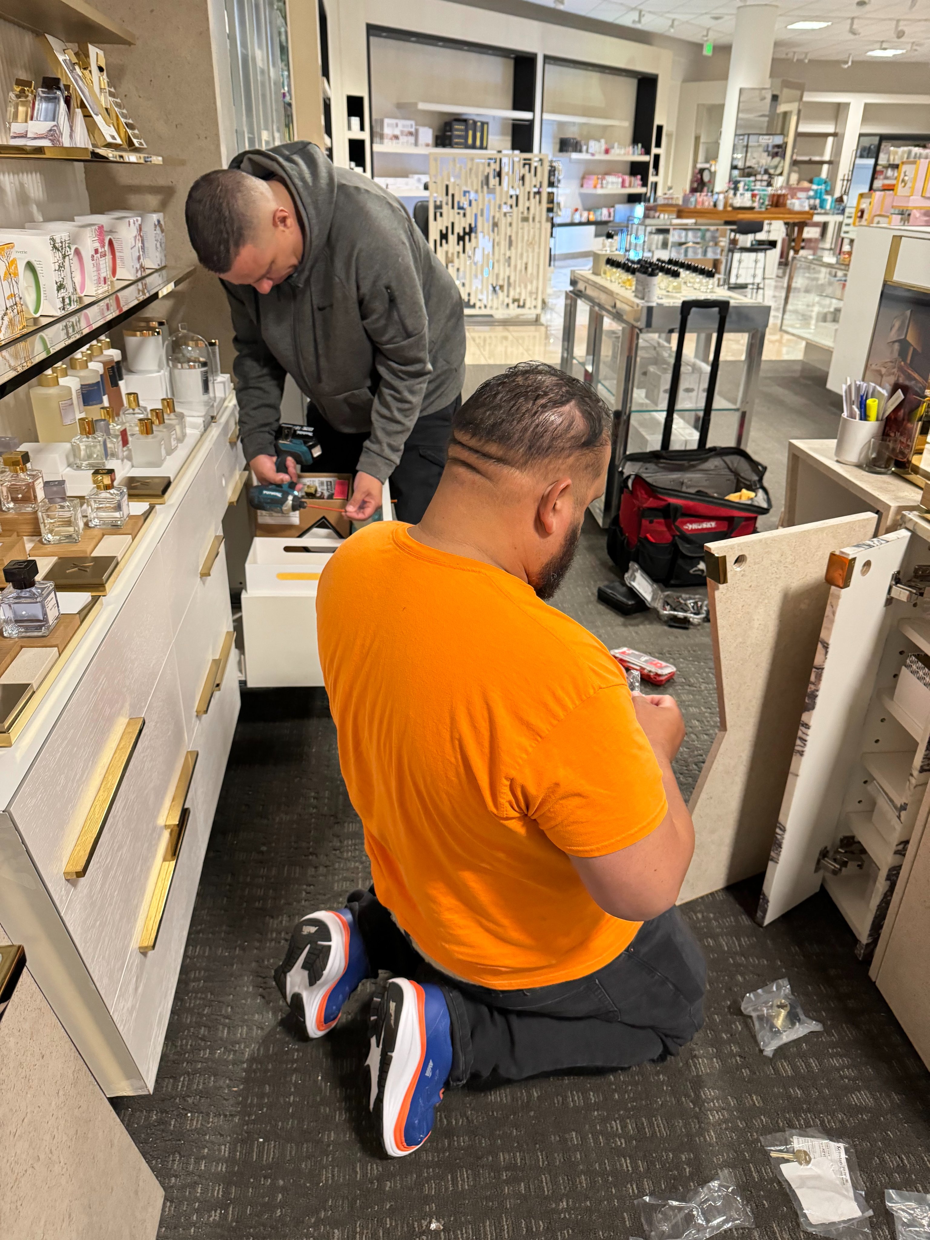 Our team working with precision on a fragrance counter installation.