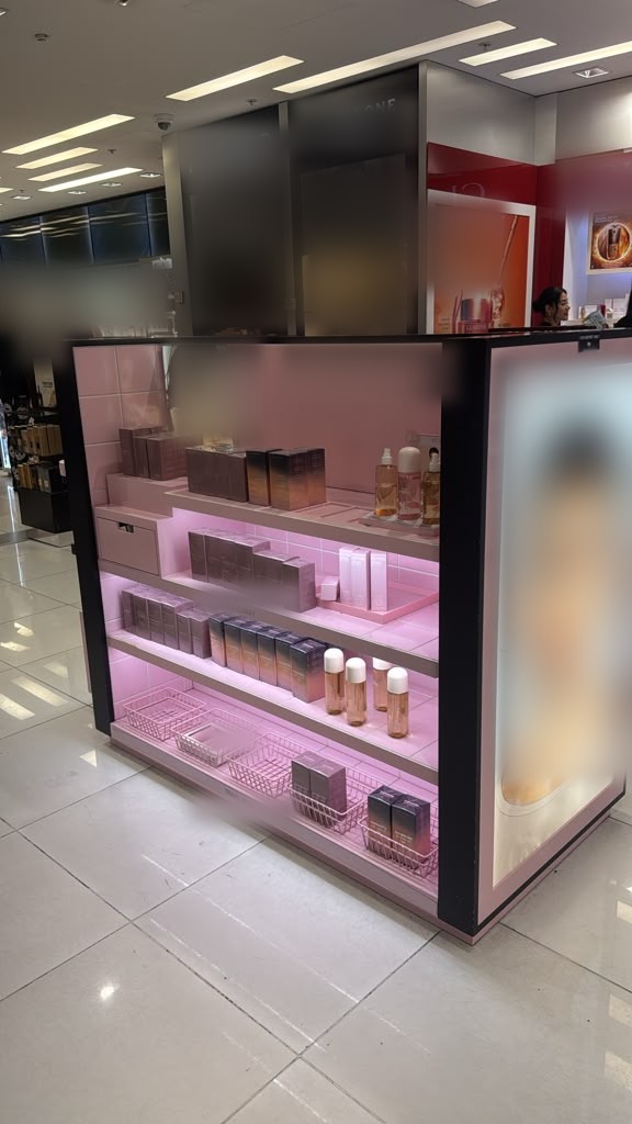 Freestanding kiosk with tiered shelves, integrated lighting and aligned panel finishes.