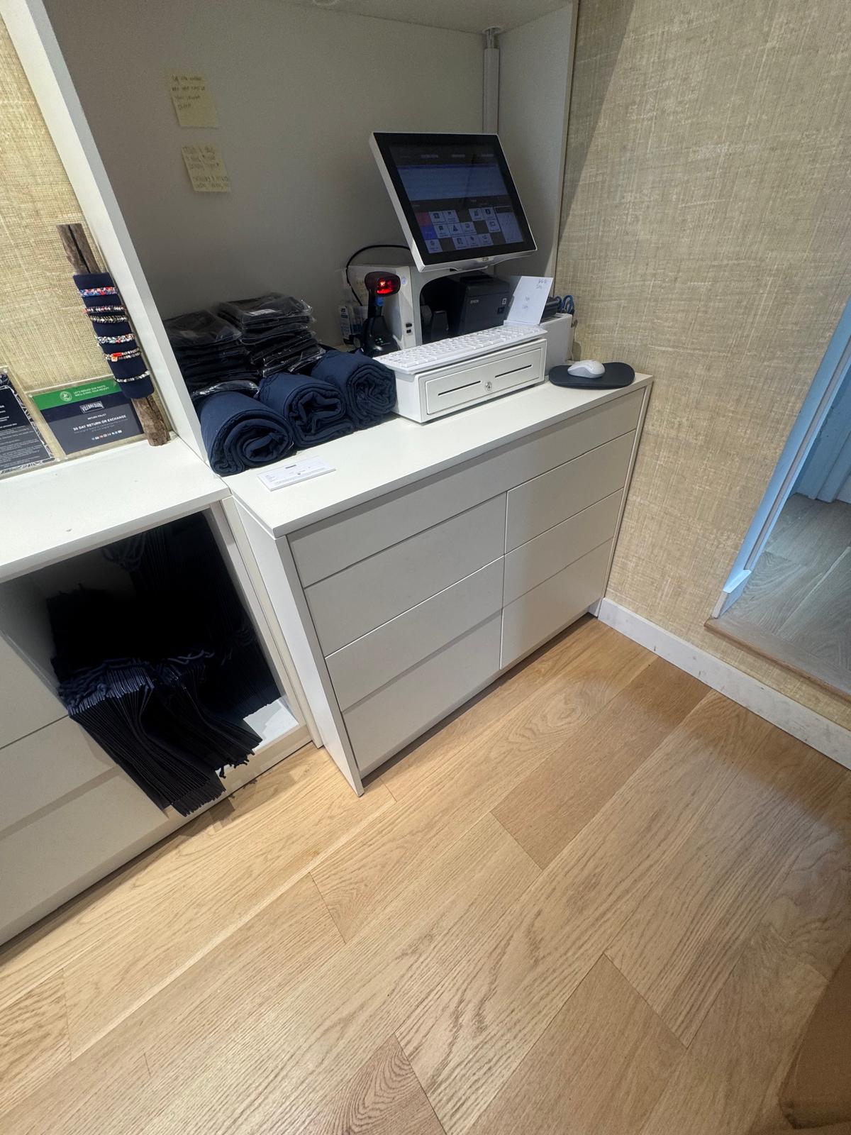 Finished point-of-sale station with the terminal, printer and cash drawer integrated into the cabinetry.