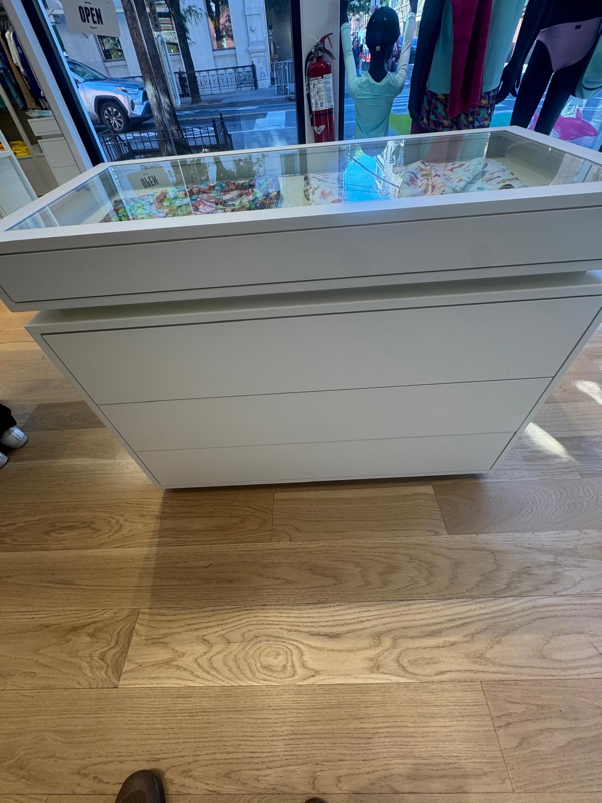 Glass-topped display counter positioned by the entrance, with clean edges and level seating.