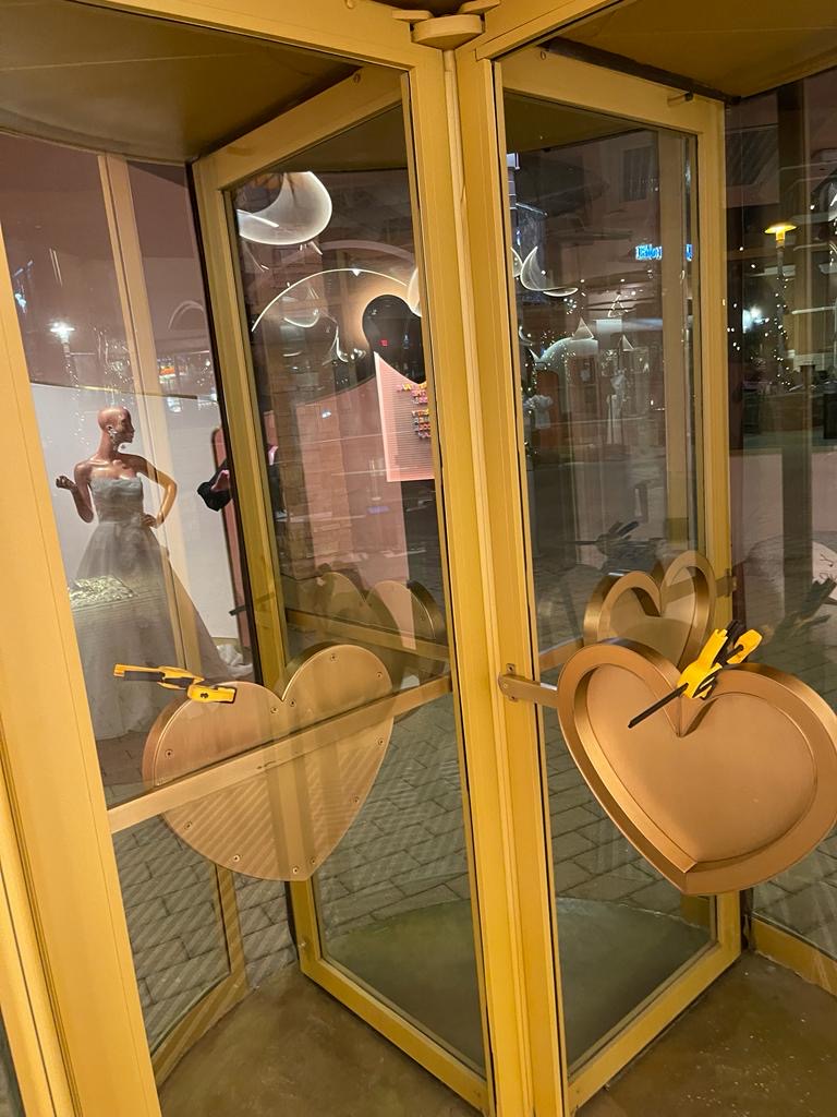 Paired elements aligned across adjoining glass panels.