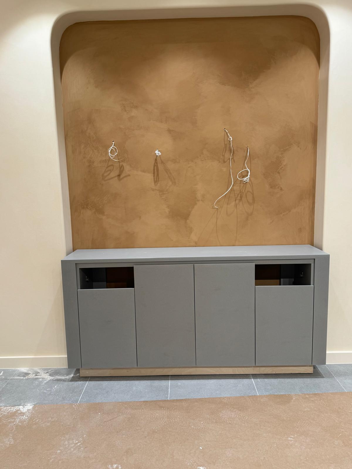 Finished grey cabinetry seated cleanly within the recess.