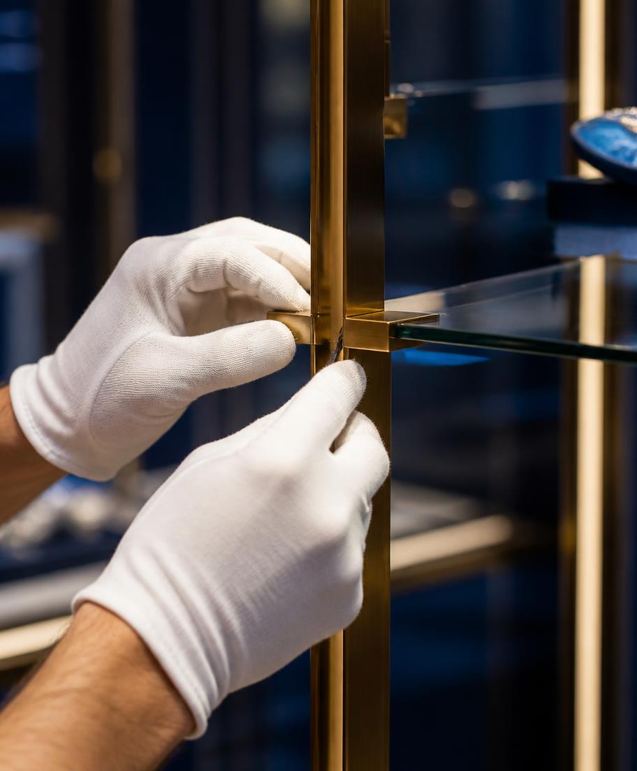 Craftsperson precisely adjusting a brass and glass fixture